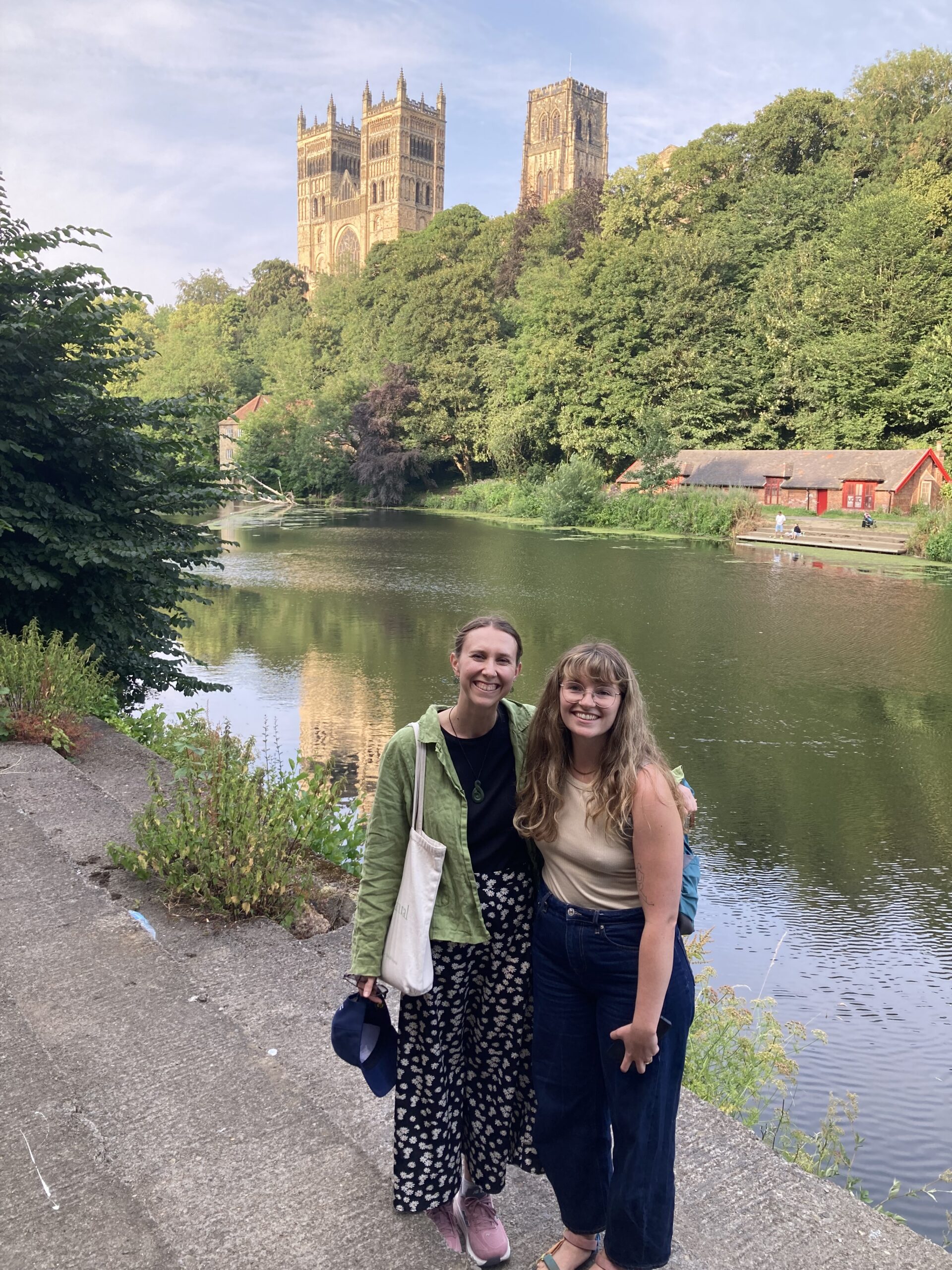 Two white women stand in the foreground of the picture. Behind them is the River Wear and Durham Cathedral.