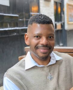 An image of Garfield's face. Garfield has short, black hair; brown skin and is smiling in this photo.